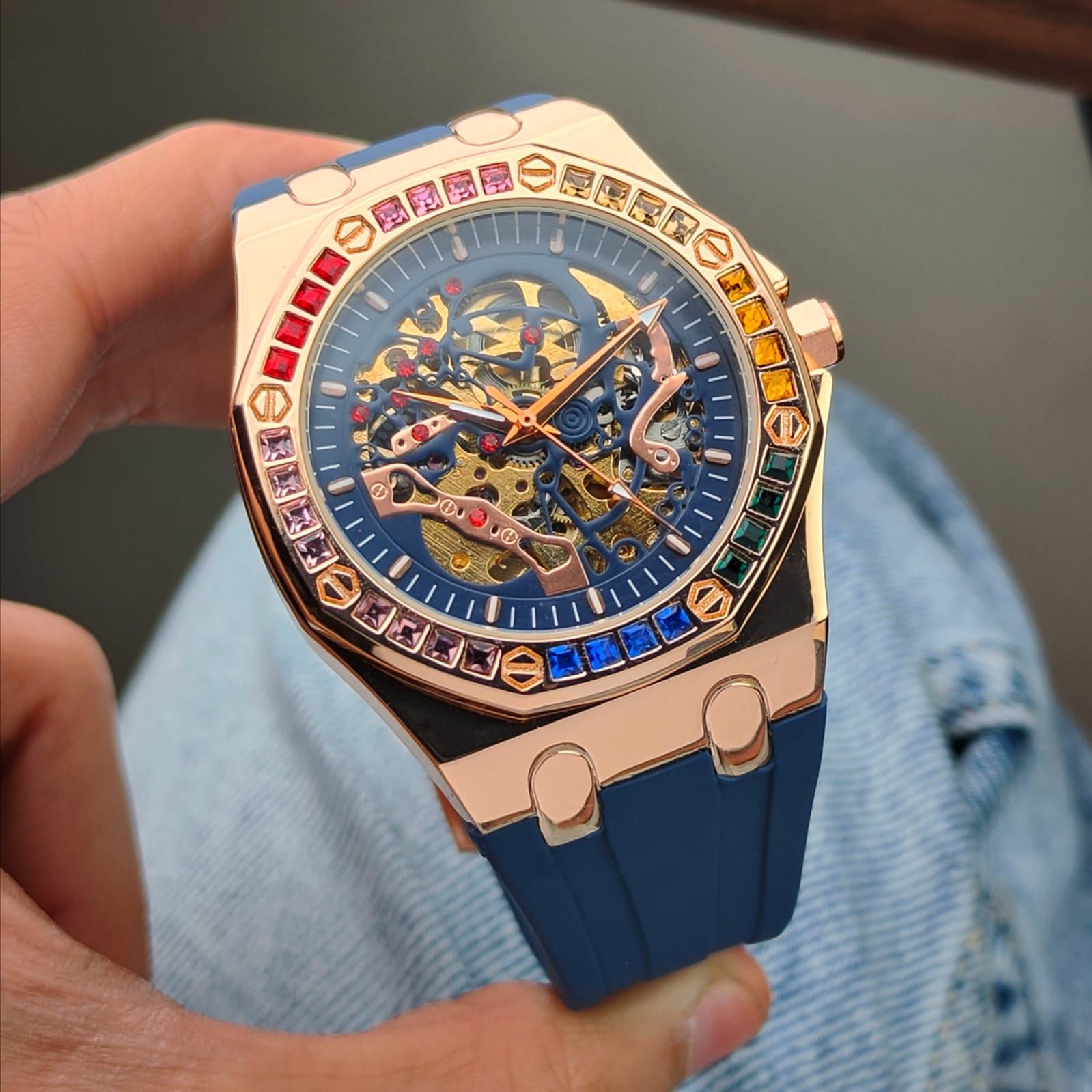 AUDEMAR_S PIGUET AUTOMATIC MECHANICAL WATCH WITH A SKELETON DIAL A ROSE GOLD TONE ALLOY CASH AND A BLUE SILICONE STRAP